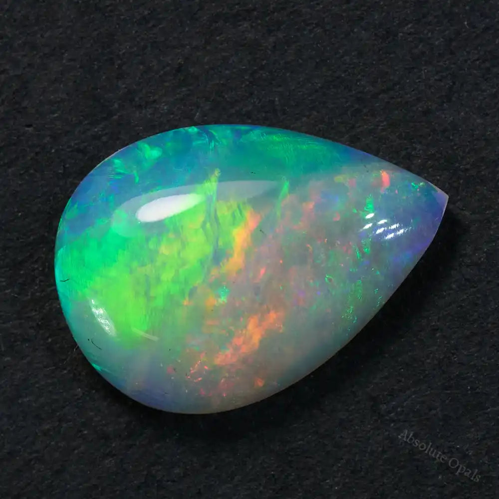 0.88 cts South Australian opal crystal with vibrant orange, yellow, and green colors in teardrop cut.