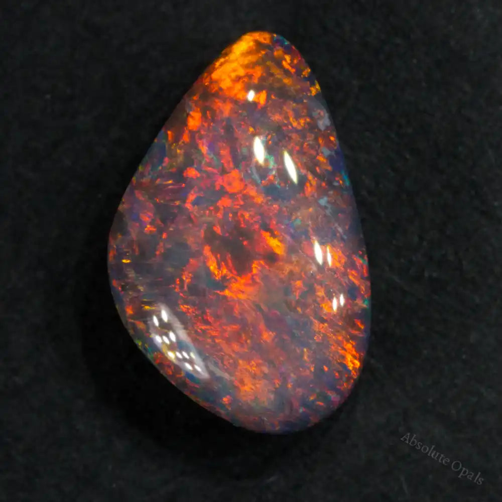 Teardrop-shaped black opal weighing 1.86 cts, showcasing vibrant dark orange and red colors.