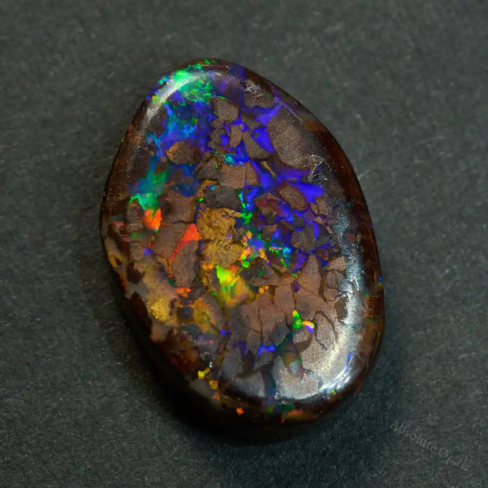 Boulder Opal Cut Stone – Natural Australian opal with vibrant red, green, and blue play of color. Polished and ready for jewelry or collection.