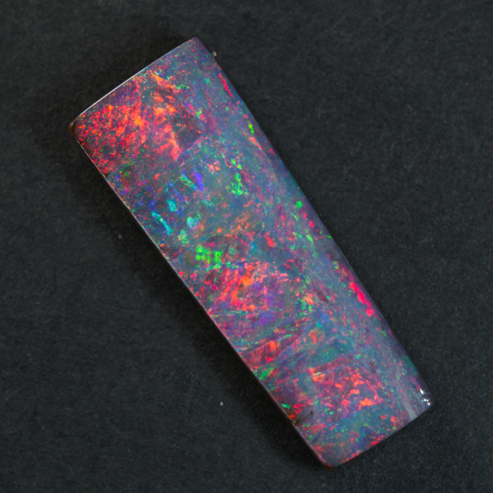 4.52 cts Boulder Opal cut stone with vibrant red and multi-coloured patterns, ideal for jewelry creation.