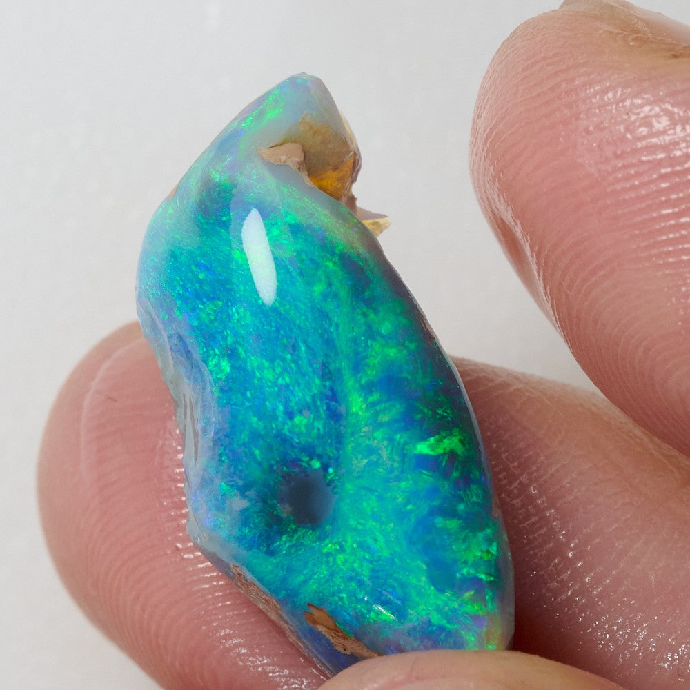 Close-up of a 10.95 cts rough opal rub, showcasing vibrant green hues from Lightning Ridge, Australia.