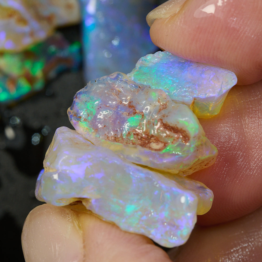 Close-up of rough opal pieces showing vibrant green and blue hues, ideal for crystal inlay projects.