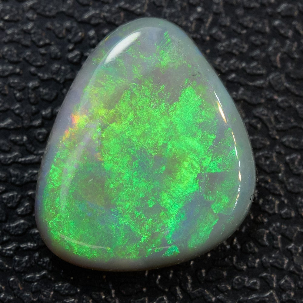 1.46 cts triangular dark opal from Lightning Ridge with vibrant green color, low dome and unique patterns.