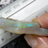 Close-up of 124 cts rough green/blue opal from South Australia held next to a ruler for size comparison.