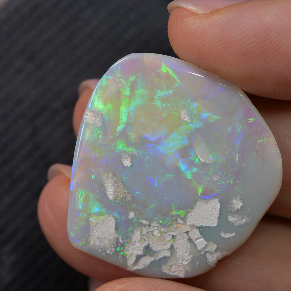 Natural green opal rough specimen from Lightning Ridge, Australia, displaying vibrant green flashes of colour in the host stone