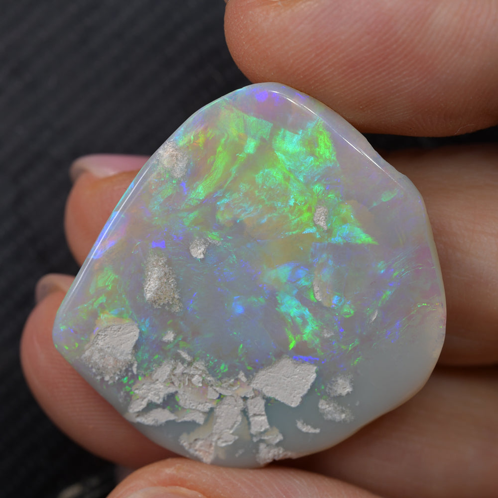 Natural green opal rough specimen from Lightning Ridge, Australia, displaying vibrant green flashes of colour in the host stone