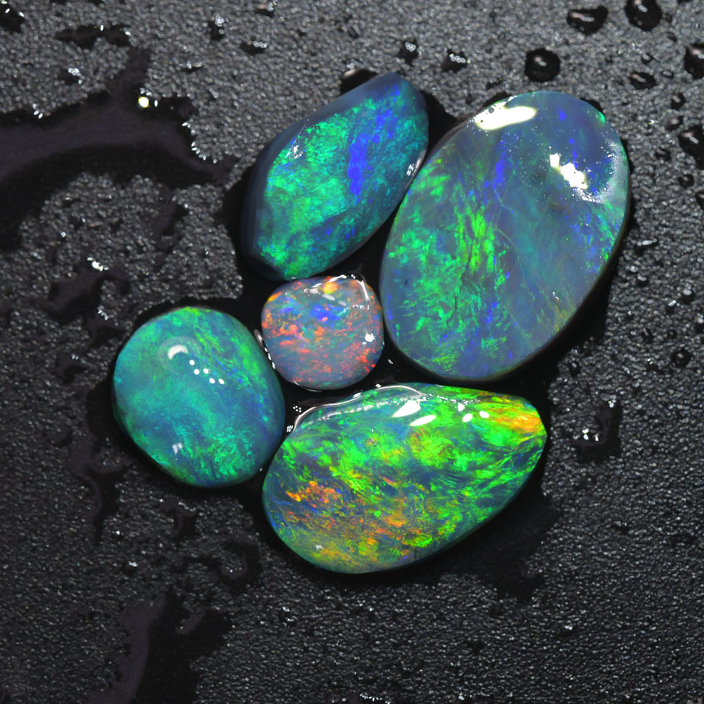 Gem rough black opal parcel from Lightning Ridge, Australia, containing opal rubs with vibrant red and green flashes of natural colour
