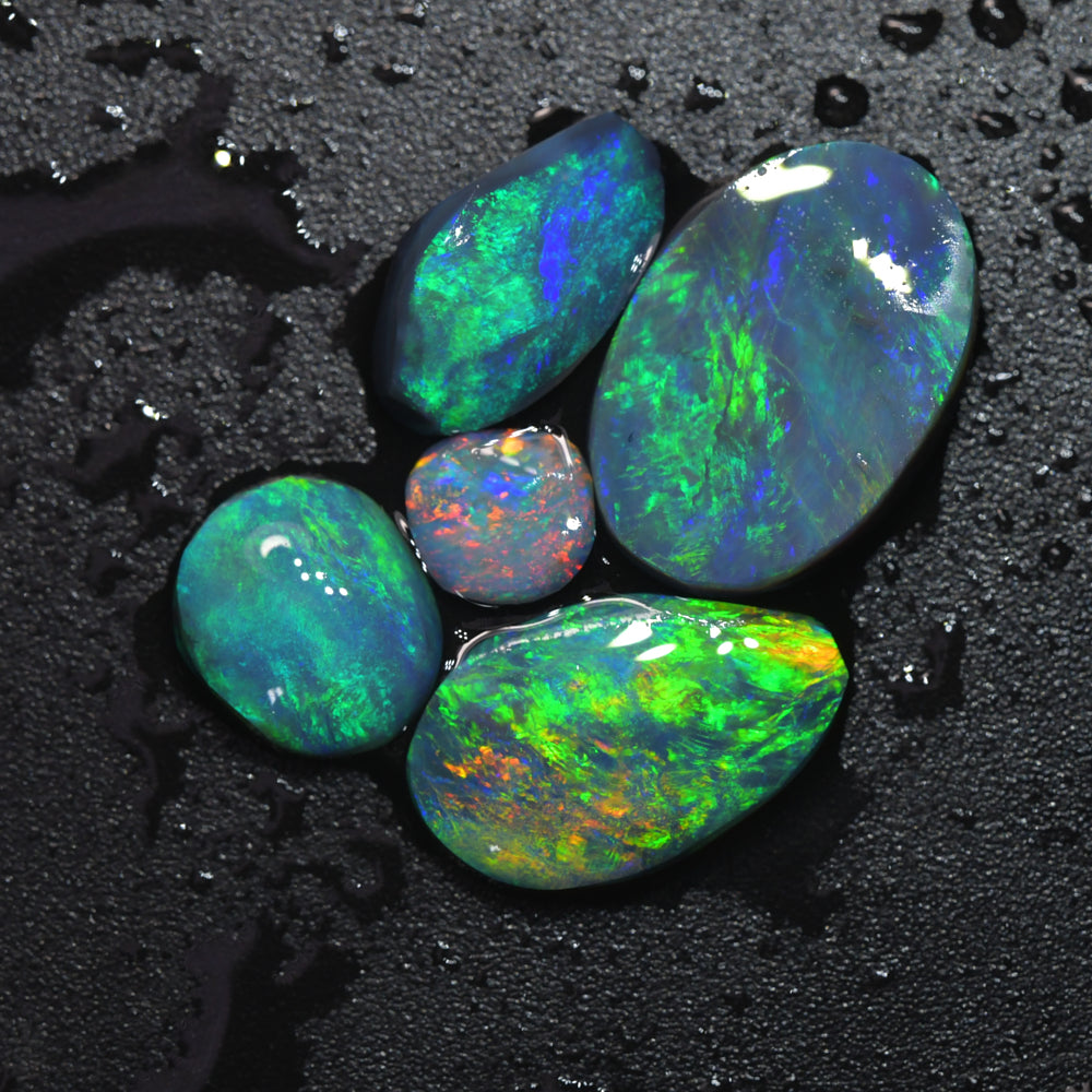 Australian Lightning Ridge gem rough black opal parcel featuring opal rubs with vivid red and green colour flashes, ideal for cutting, polishing, lapidary work, jewelry making, and collecting