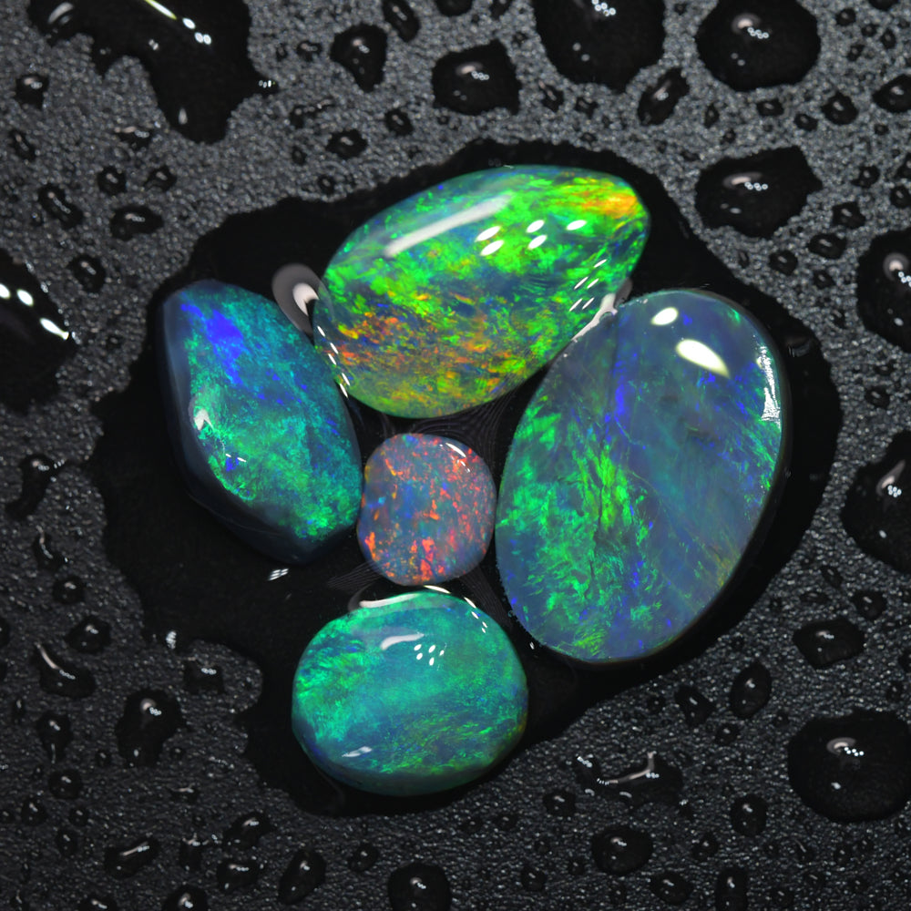 Gem rough black opal parcel from Lightning Ridge, Australia, containing opal rubs with vibrant red and green flashes of natural colour