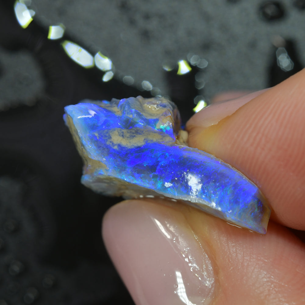 Rough black opal carving from Lightning Ridge, Australia, featuring natural colour and hand-carved opal material
