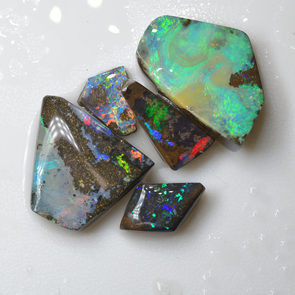 Australian boulder opal rough parcel rubs featuring vivid red and green colour flashes, ideal for cutting, polishing, lapidary work, and gemstone collecting
