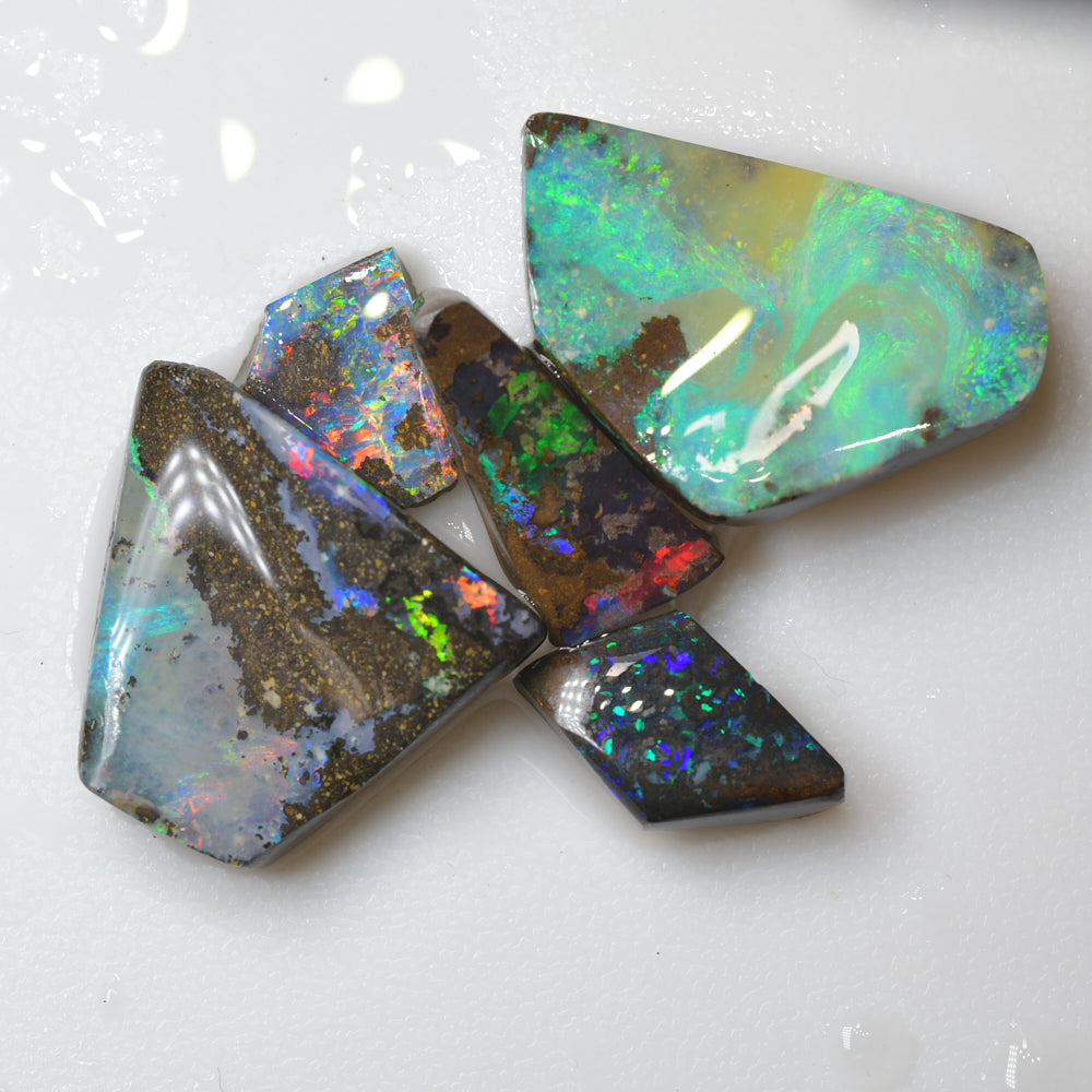 boulder opal rough parcel rubs displaying vibrant red and green flashes of natural colour in Australian boulder opal