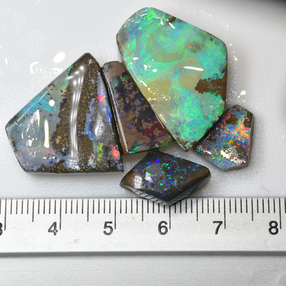boulder opal rough parcel rubs displaying vibrant red and green flashes of natural colour in Australian boulder opal