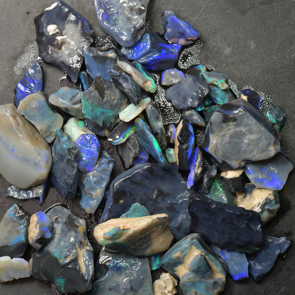 Rough black opal parcel from Lightning Ridge, Australia, featuring natural potch with flashes of colour in untreated opal rough