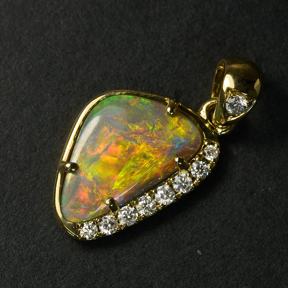 Genuine opal pendant from Lightning Ridge set in 14K gold with diamond accents, showcasing vibrant multicolors.