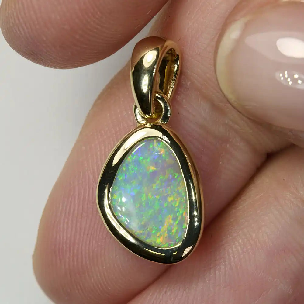 Elegant South Australian opal pendant in 14K gold shown on model – genuine solid opal with shimmering colors.
